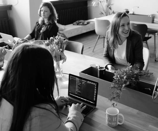 three women in a work meeting table