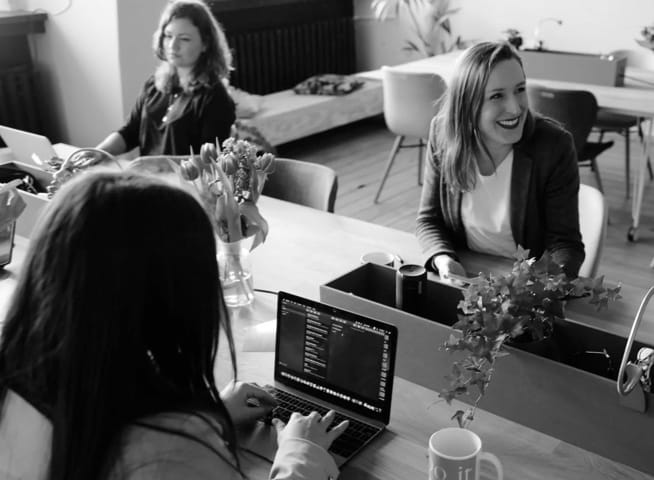 three women in a work meeting table